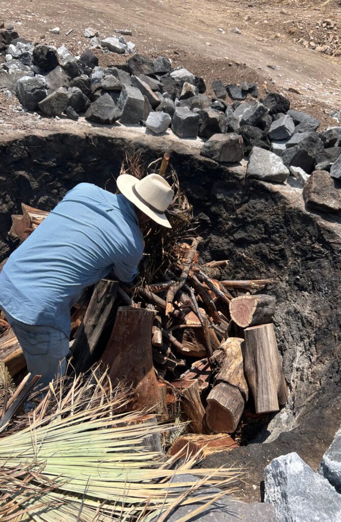 A man in blue shirt and hat digging through rocks.